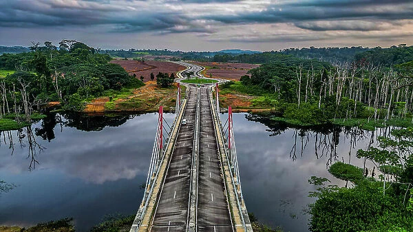 Background Image of Aerial of a bridge cutting through the jungle to